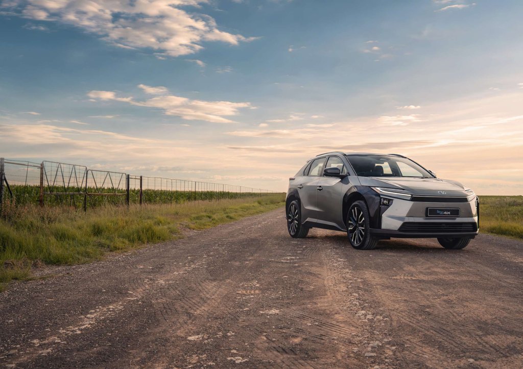 Toyota bZ4X battery-electric SUV parked on a gravel farm road in South Africa at sunset