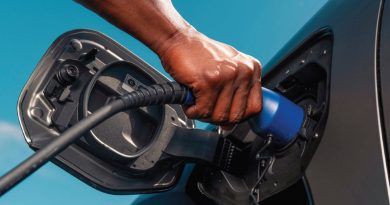 Driver plugging a charging connector into the Toyota bZ4X charge port